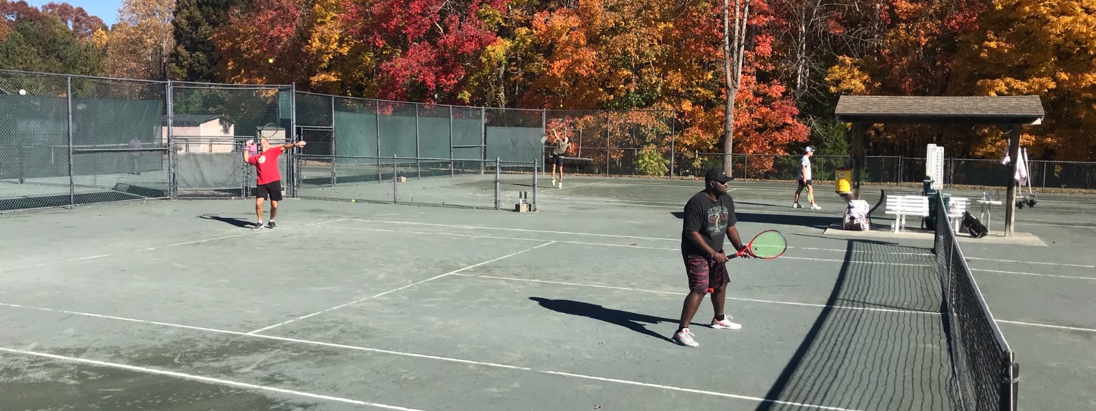 Adults playing on the clay courts on a bright fall afternoon