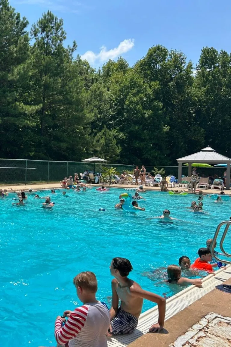 Members swimming and relaxing at the outdoor pool on a sunny day at Asheboro Racquet & Swim Club