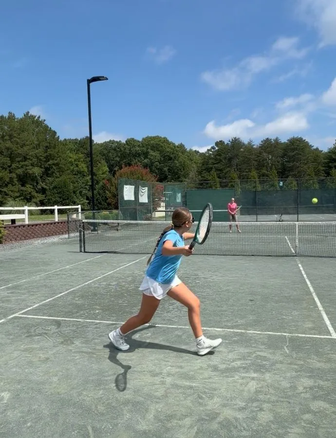 Junior player hitting a backhand during a tennis rally at Asheboro Racquet & Swim Club
